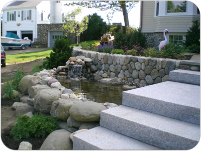 Picture of a small accent waterfall and granite steps, round stone wall